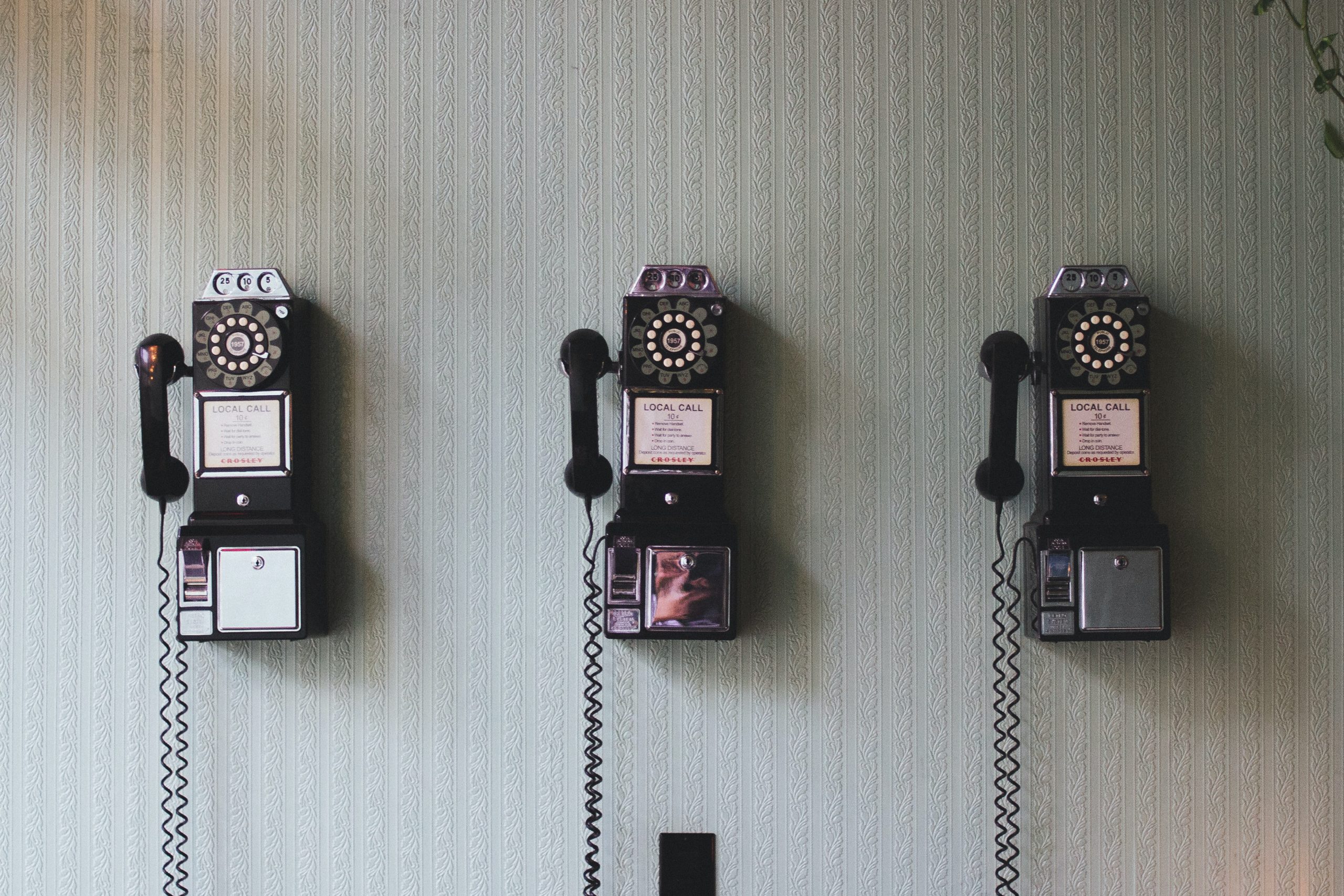 Three telephones hung on the wall